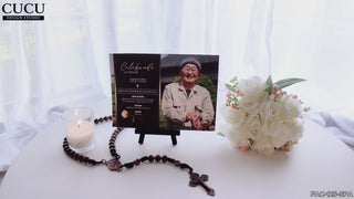 Invitación de funeral elegante negro con foto de persona mayor sobre mesa con vela encendida, rosario y flores blancas, plantilla editable en Canva en español para memorial / Elegant black funeral invitation with elderly portrait displayed on table with lit candle, rosary and white flowers, Spanish editable Canva memorial template