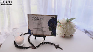 Tarjeta de funeral presentada sobre mesa con vela encendida, rosario y flores blancas, diseño elegante en azul y dorado mostrado en caballete, plantilla editable en Canva fácil de usar, descarga inmediata perfecta para crear un homenaje significativo sin experiencia / Funeral card displayed on table with lit candle, rosary and white flowers, elegant blue and gold design shown on stand, editable Canva template easy to use with instant download, perfect for creating a meaningful tribute with no experience